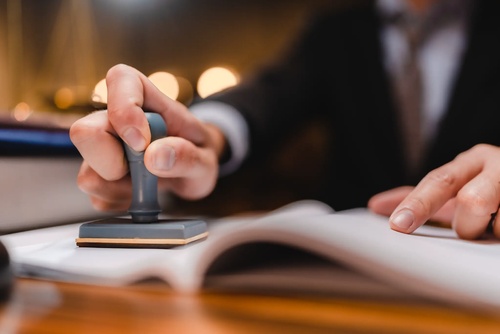 Einreichpläne und behördliche Genehmigungen Stempel für rechtliche Dokumente symbolisiert Erstellung von Einreichplänen und Koordination behördlicher Genehmigungen