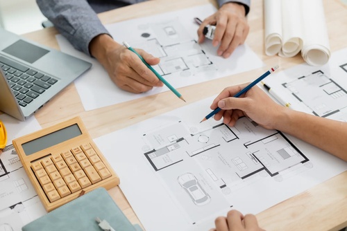 Raumanalyse und Planungsskizzen Planungstreffen mit Grundrissen, Taschenrechner und Notizen für Raumanalyse